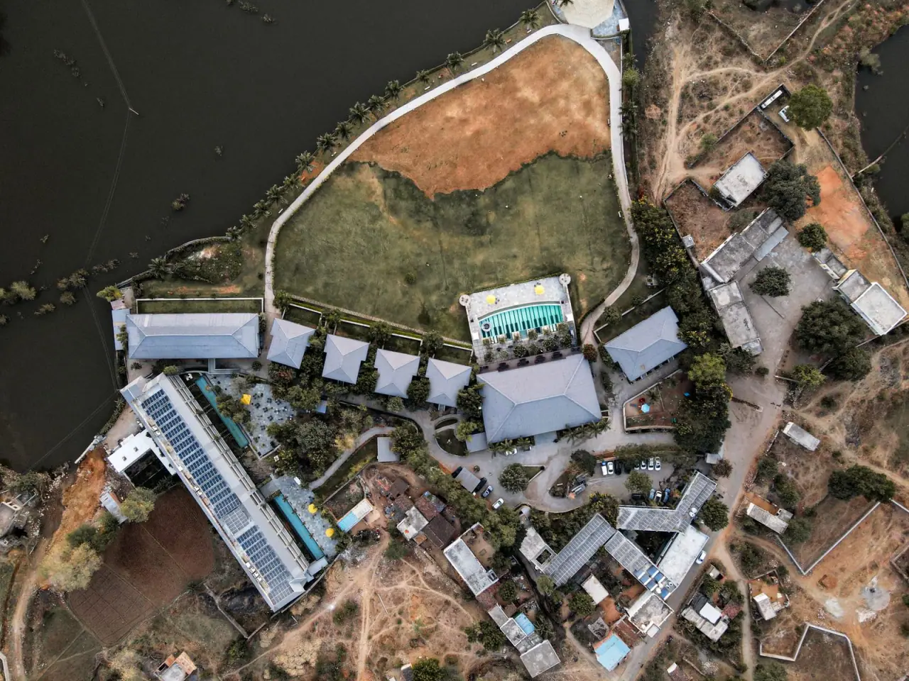 Aerial view of a resort with a pool courtyard and wide flat roof areas