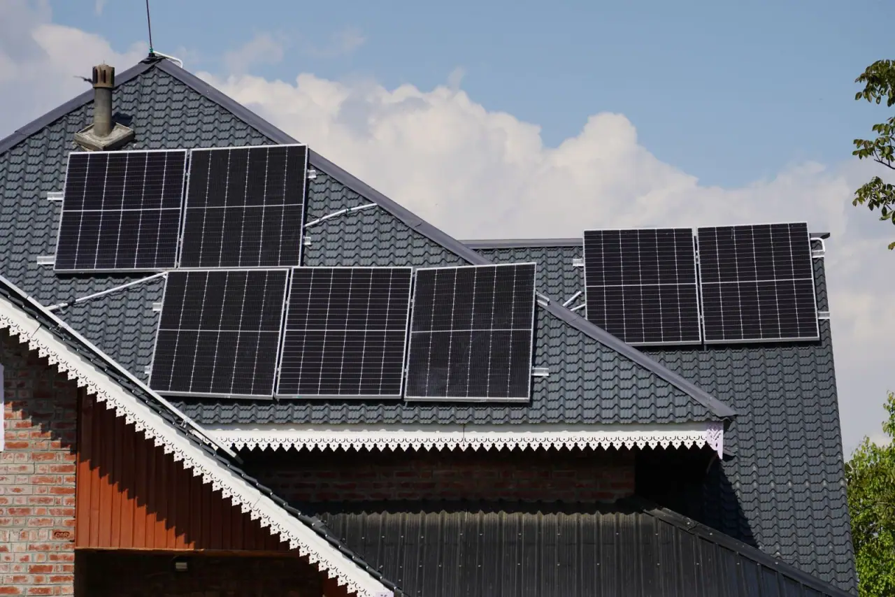 Solar modules fitted to the pitched roof of a house against a clear sky